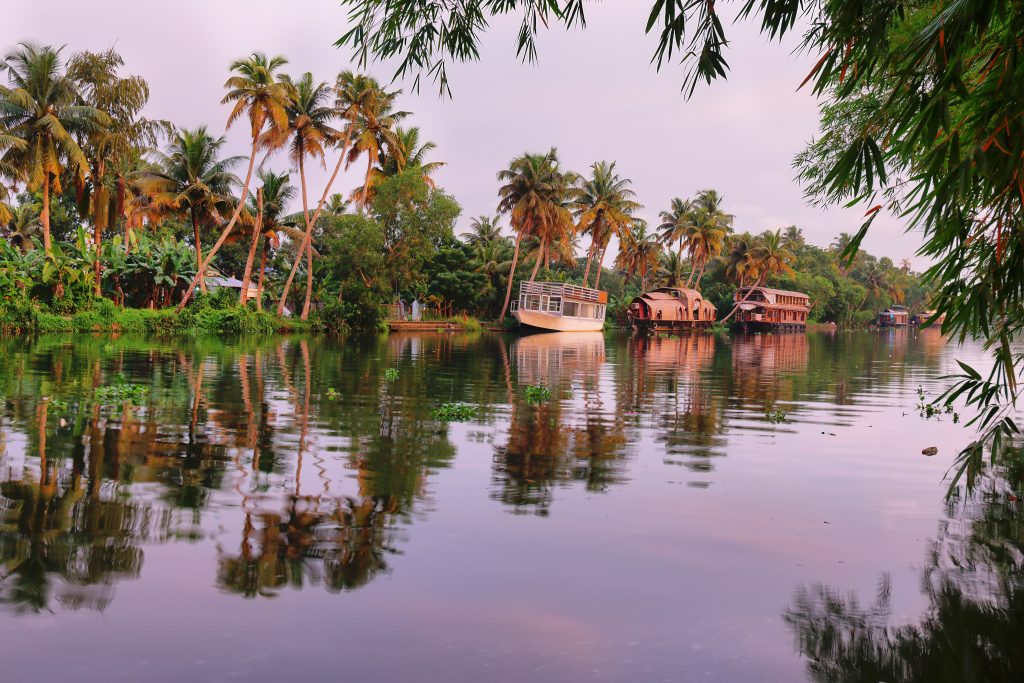 Boats on the riverbank of the backwaters in Allepey, Kerala at sunset, India.